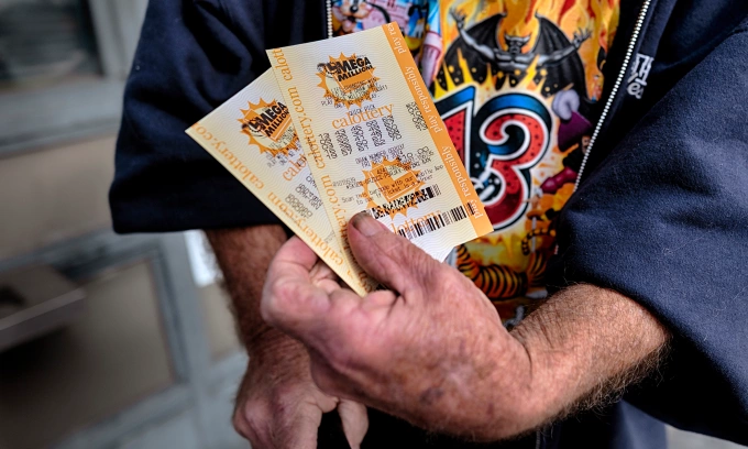 Người dân Mỹ khoe tờ vé số Mega Millions mua tại bang California hôm 27/12. Ảnh: AP